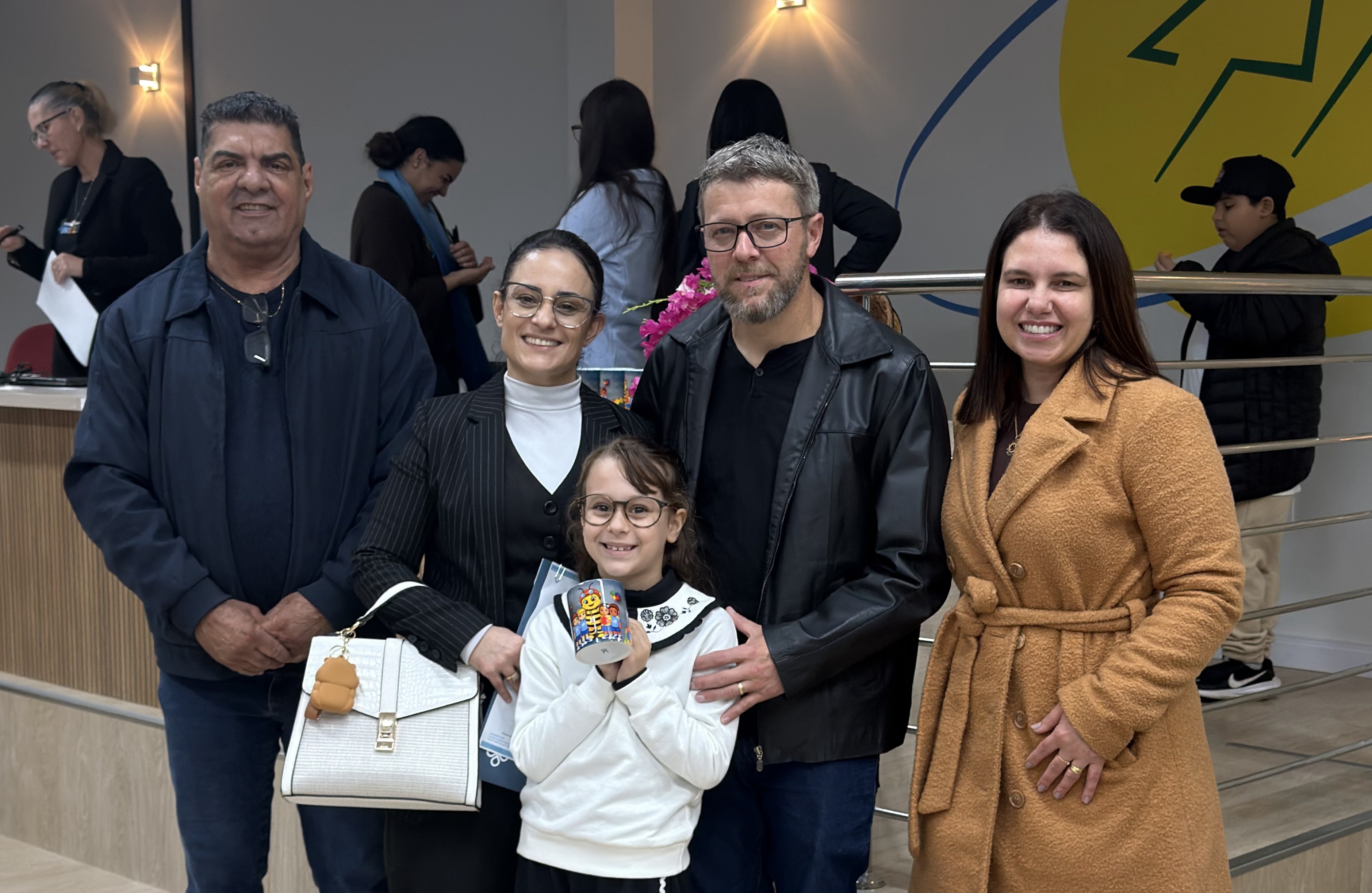 Entrega de PDI Centro Coopercocal Inclusiva - Lourival de Melo, o Belha, e Mirian Geremias, ao lado dos pais e da aluna