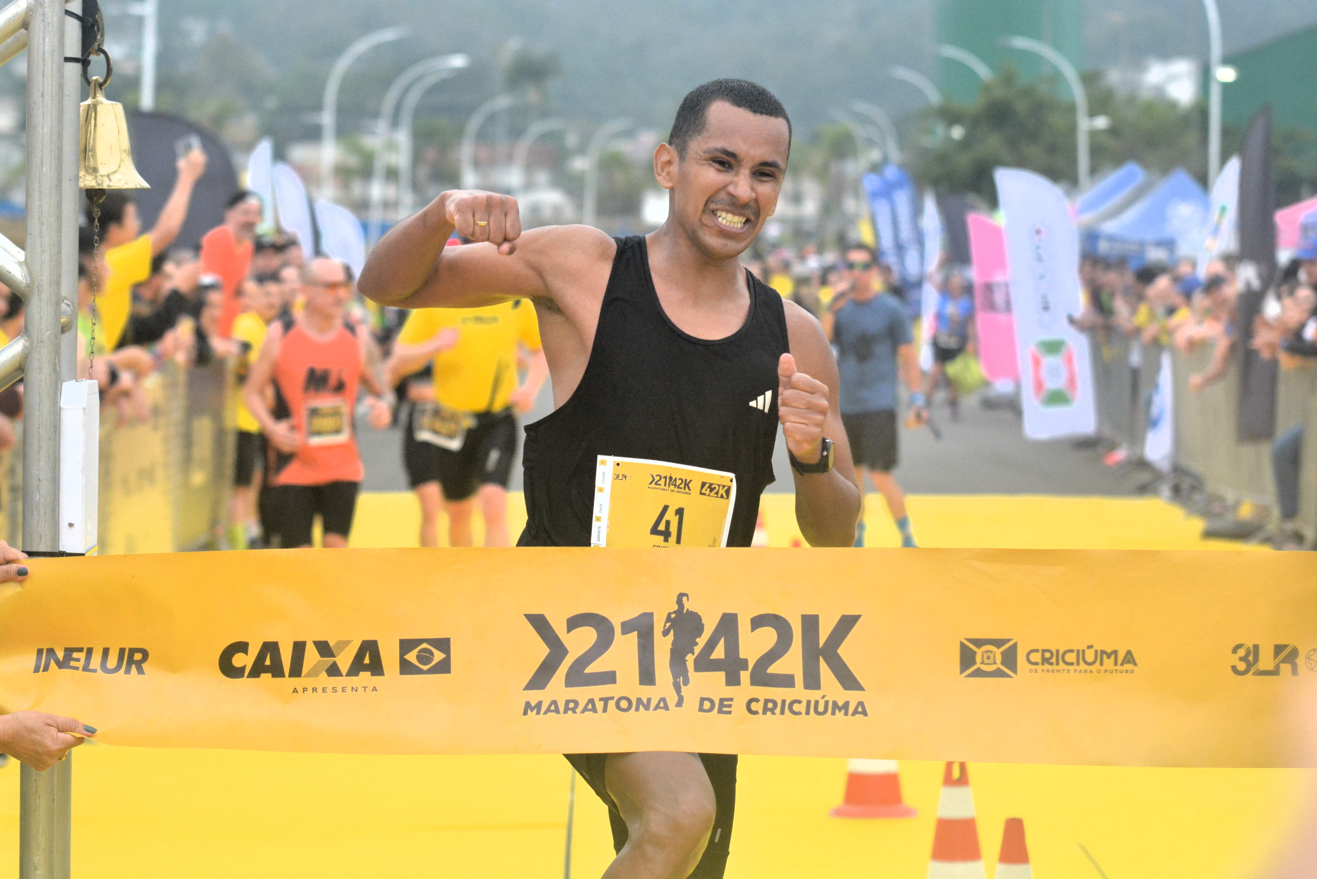 Daniel campeão da Maratona de Criciúma nos 42k passando pela linha de chegada e comemorando a vitória