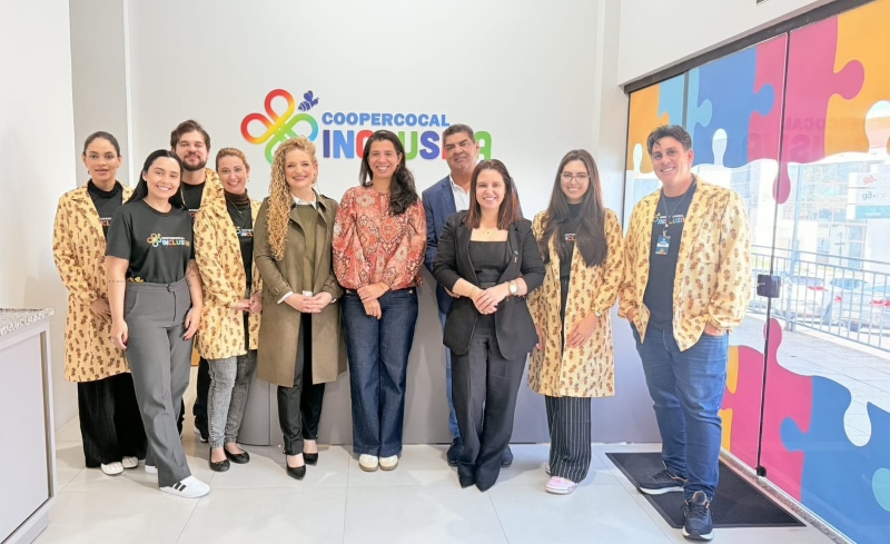 Agnes, diretora da Aneel em visita a sede da Coopercocal Inclusiva, posando para a foto ao lado dos colaboradores do projeto de atendimento as crianças autistas