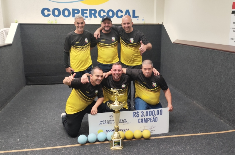 Time Amigos da Bocha posando para foto na canha da sede esportiva da Coopercocal, com o troféu de campeão