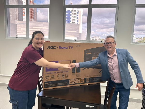 Camila Meller Manentti recebendo uma smartv da campanha Comércio Local é Legal